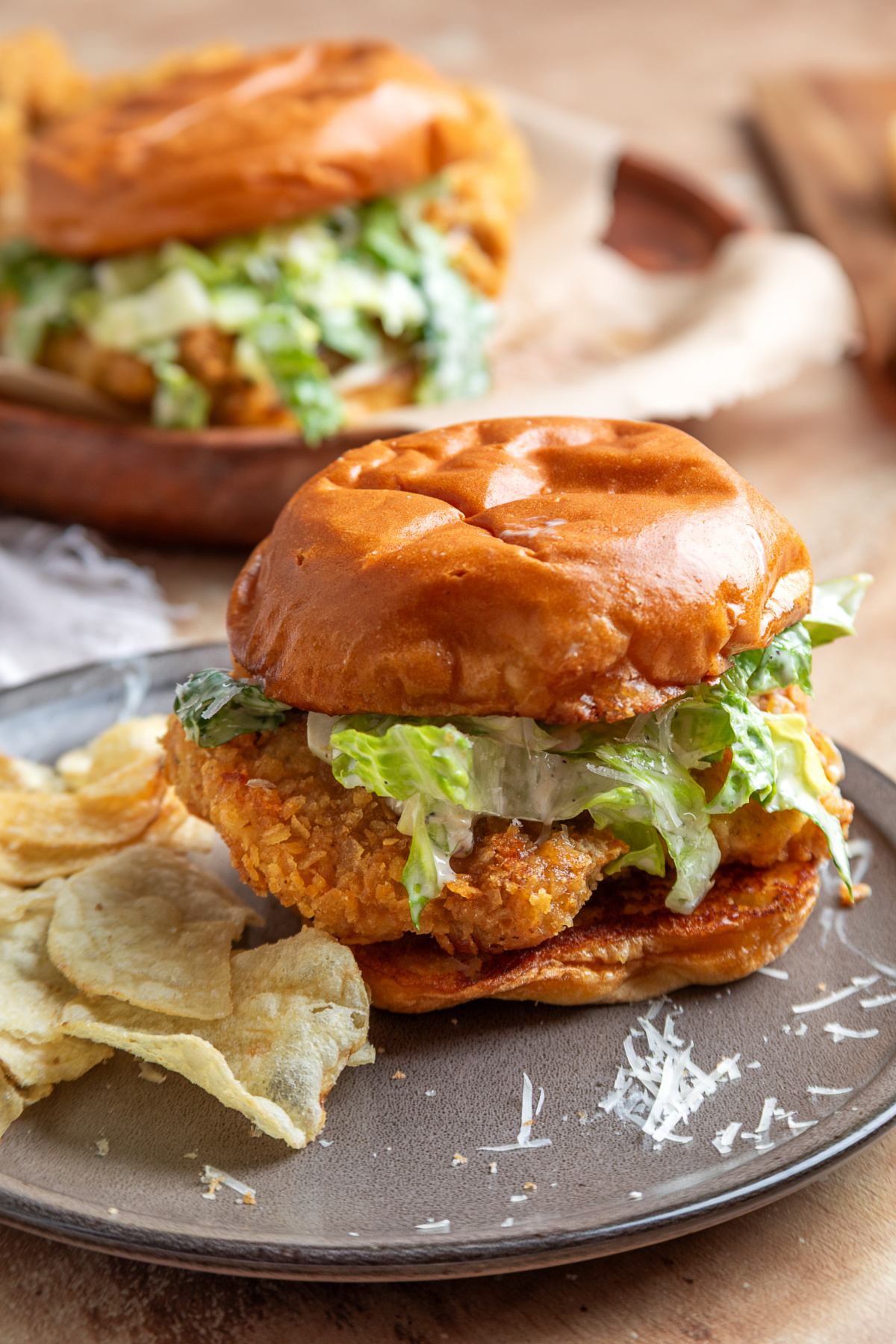 Chicken Caesar sandwich Chicken Caesar sandwich with crispy potato chip-crusted chicken, homemade Caesar salad, and a toasted brioche bun served with potato chips.