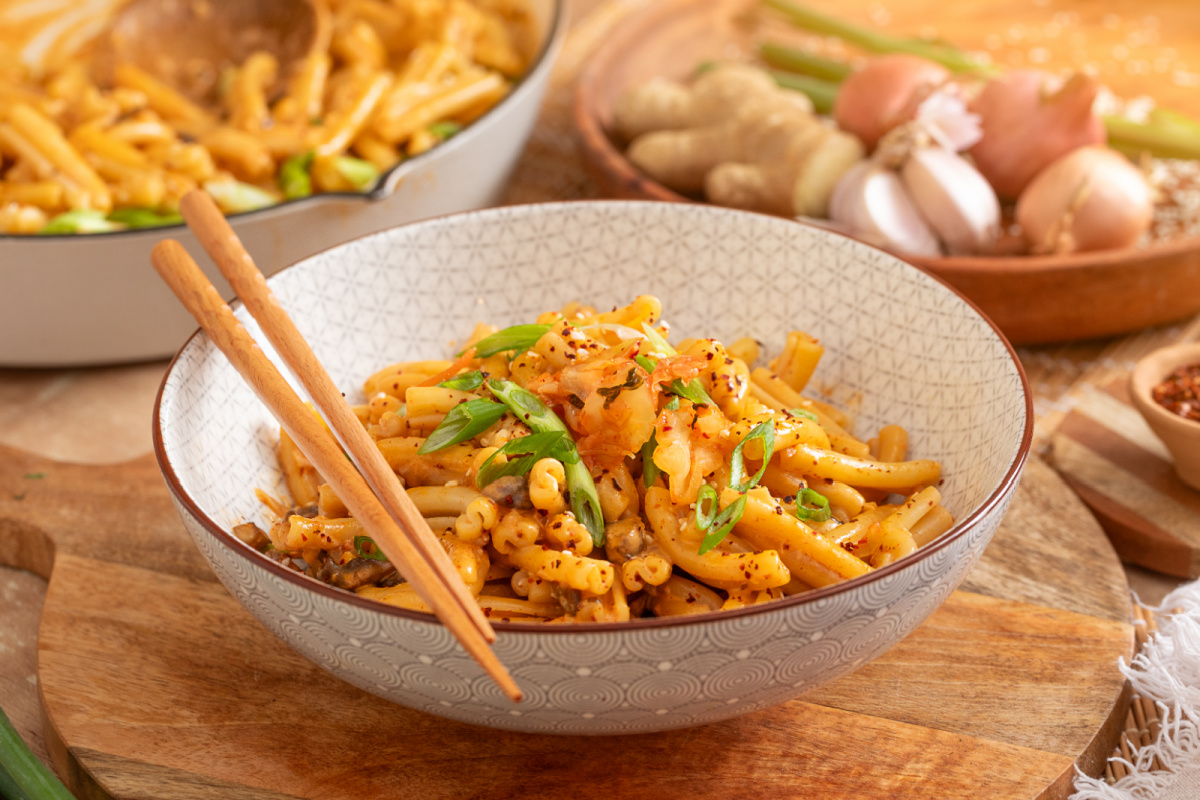 Gochujang mushroom pasta with kimchi and green onions served with chopsticks Bowl of creamy gochujang pasta with mushrooms, kimchi, green onions and gochugaru