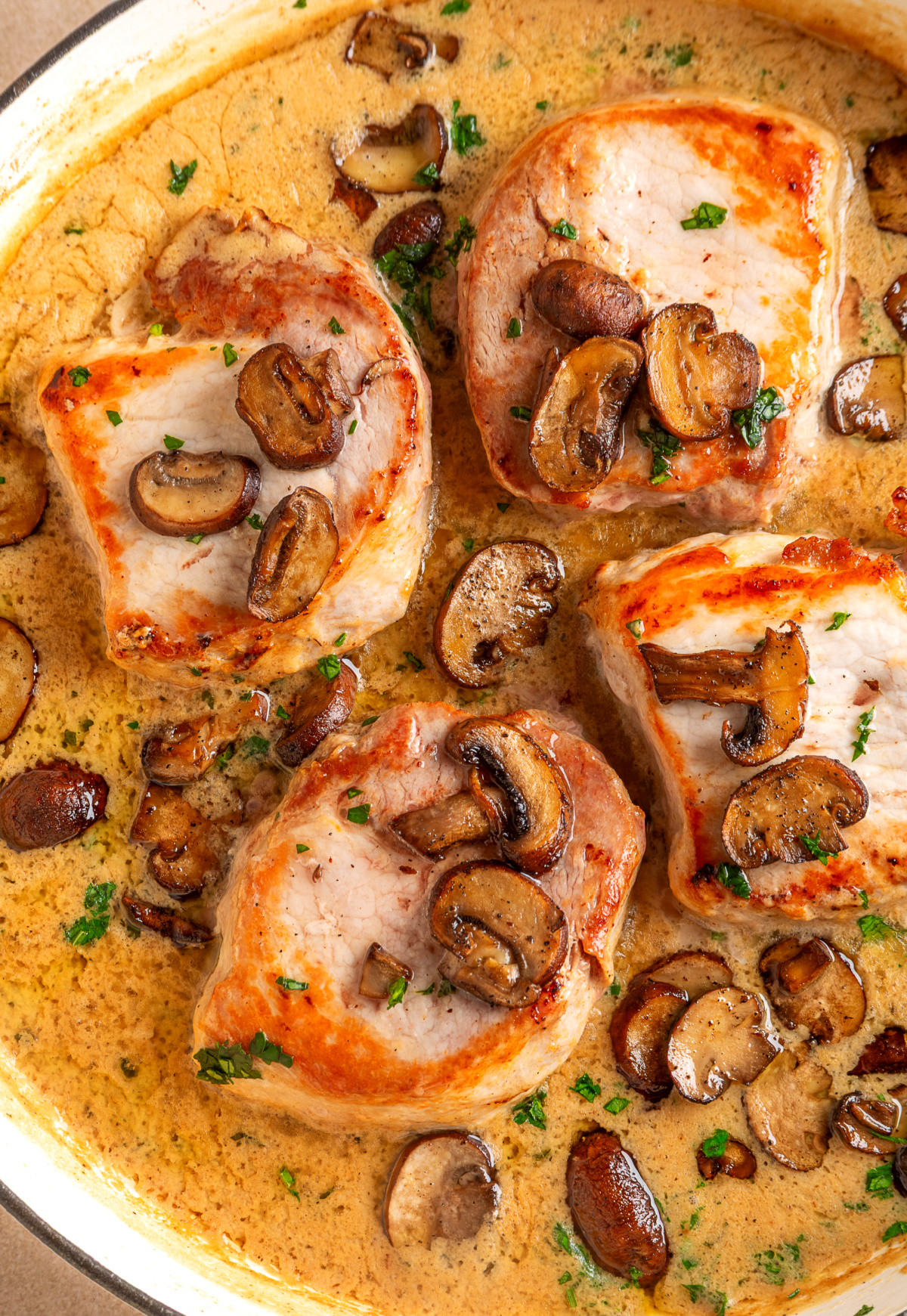 Seared boneless pork chops topped with roasted mushrooms in a creamy fresh sage sauce. Creamy mushroom pork chops with roasted mushrooms and sage cream sauce in a skillet