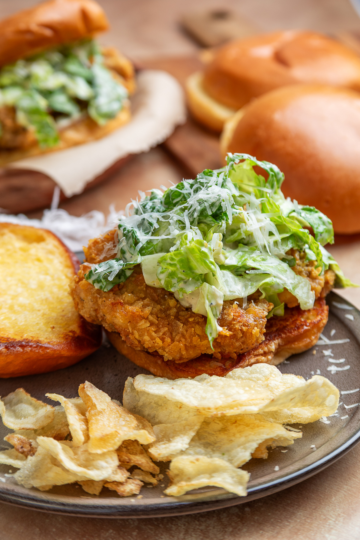 Crispy chicken Caesar sandwich Crispy chicken Caesar sandwich with potato chip-crusted chicken, homemade Caesar salad, Parmesan cheese, toasted brioche bun, and potato chips.