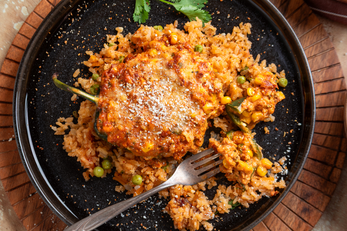Mexican street corn stuffed poblano pepper cut open to show the creamy corn, chorizo and cheese filling