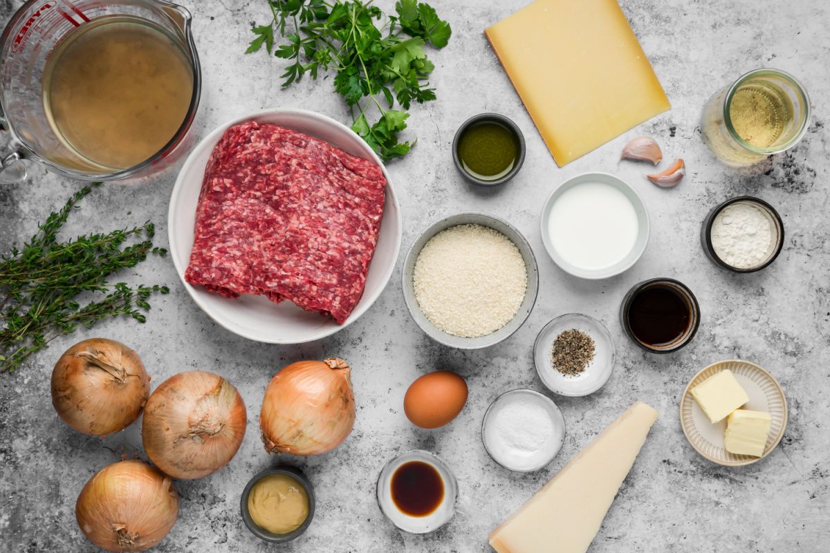 Ground beef, onions, Gruyère, Parmesan, herbs, wine and other ingredients for French onion meatballs. Ingredients for French onion meatballs including ground beef, yellow onions, Gruyère, Parmesan, panko, white wine and beef broth