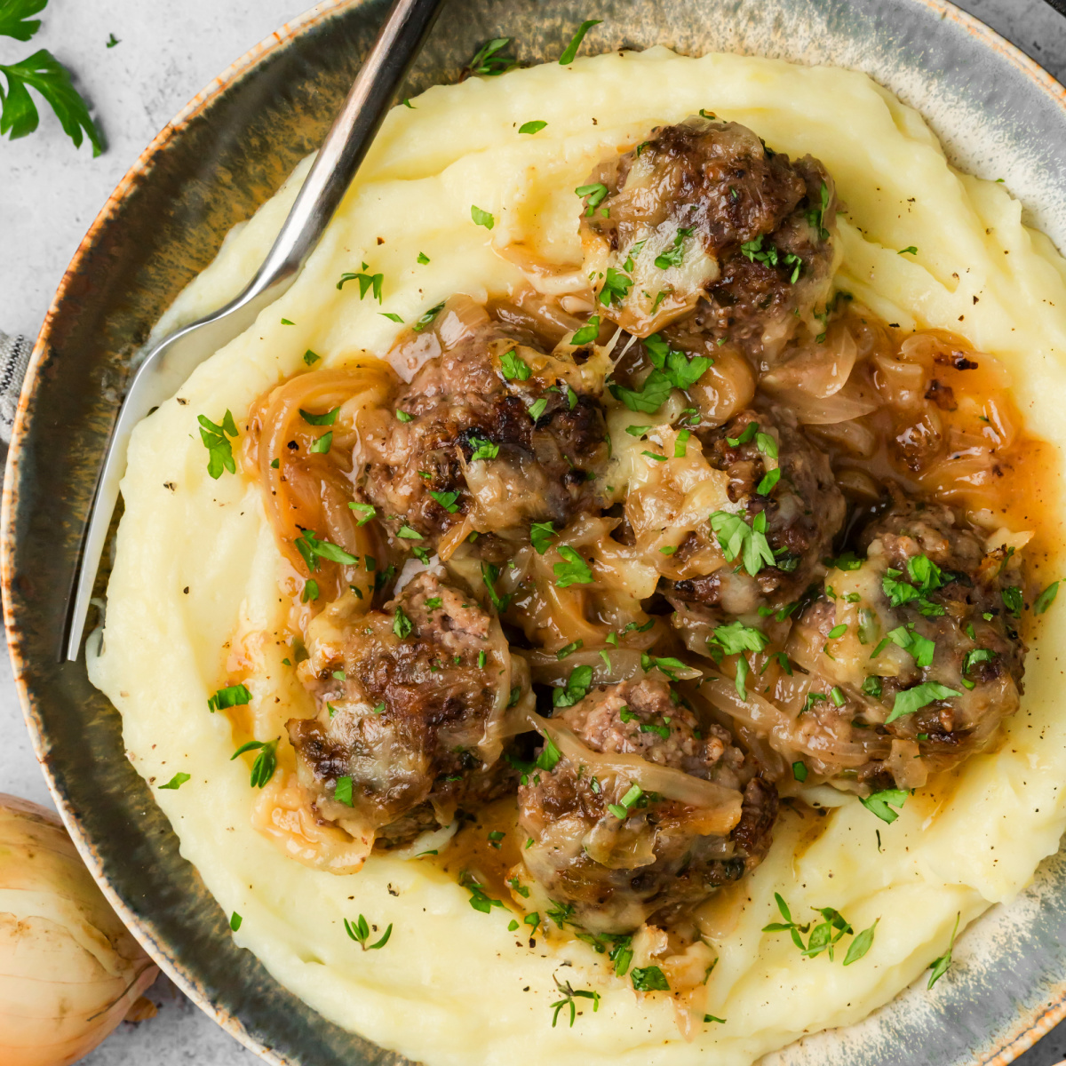 French onion meatballs with caramelized onion sauce and Gruyère served over mashed potatoes