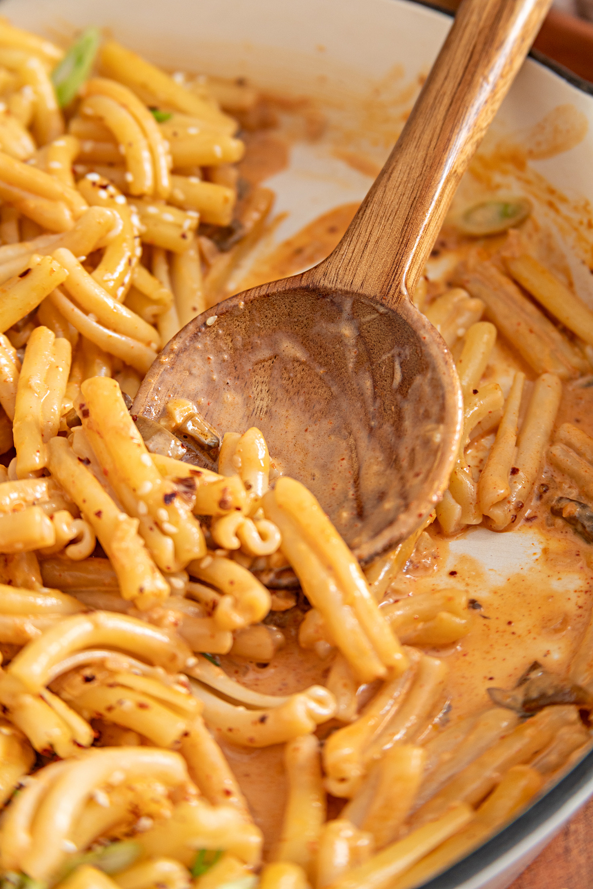 Creamy gochujang sauce coating casarecce and diced mushrooms during the final toss Casarecce and mushrooms coated in creamy gochujang sauce as the pasta is stirred in the skillet
