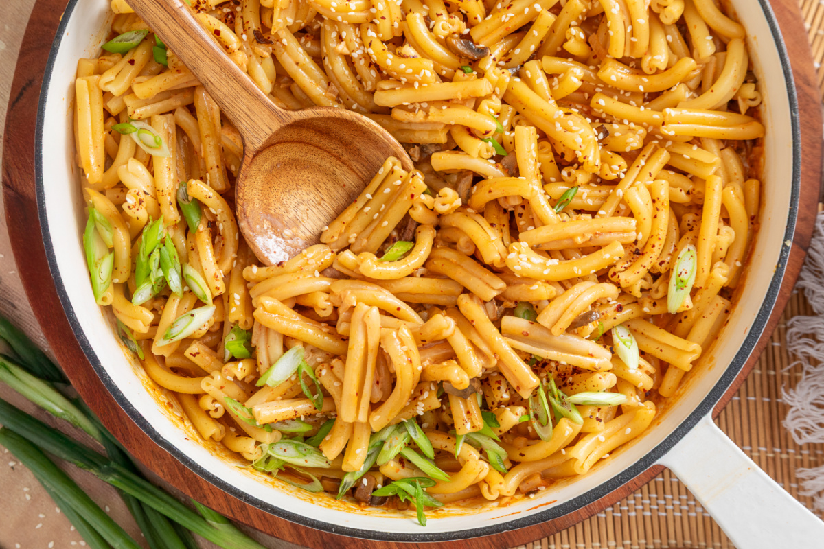 Creamy gochujang mushroom pasta finished with green onions, sesame seeds and Korean red pepper flakes Gochujang pasta with diced mushrooms, green onions, sesame seeds and gochugaru in a skillet