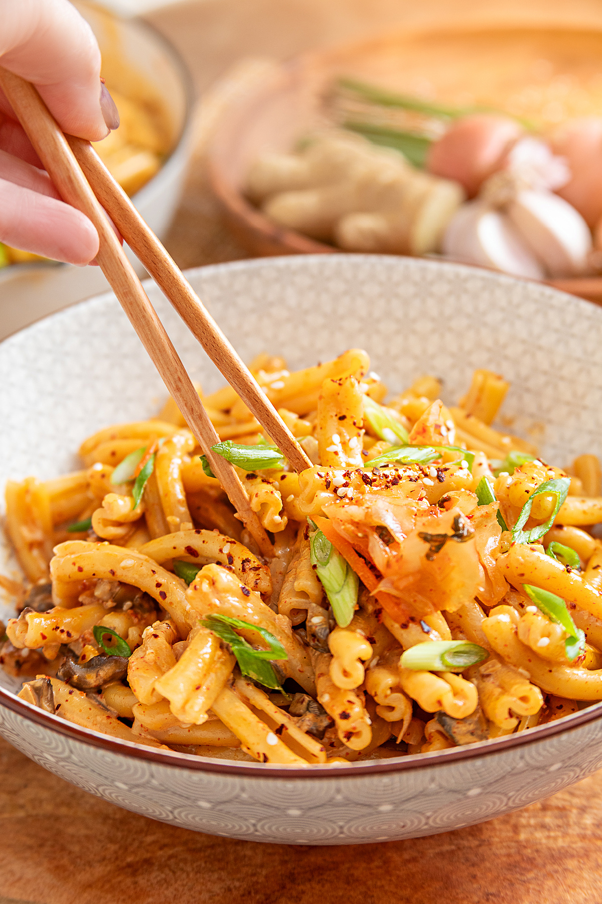 Creamy gochujang pasta topped with kimchi, sliced green onions and sesame seeds Gochujang pasta with mushrooms, kimchi, green onions and sesame seeds served in a bowl