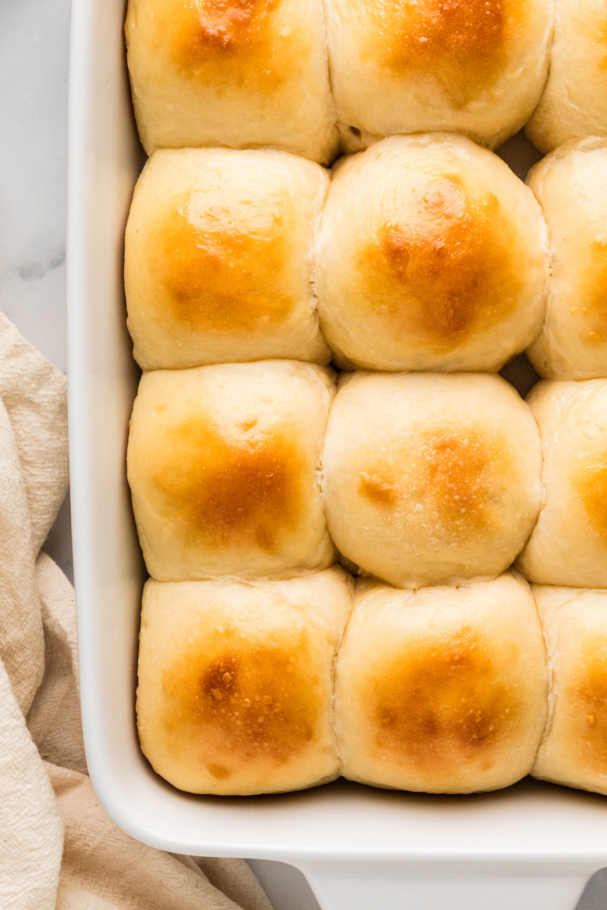 Twelve golden pull-apart dinner rolls baked together with soft pale sides.