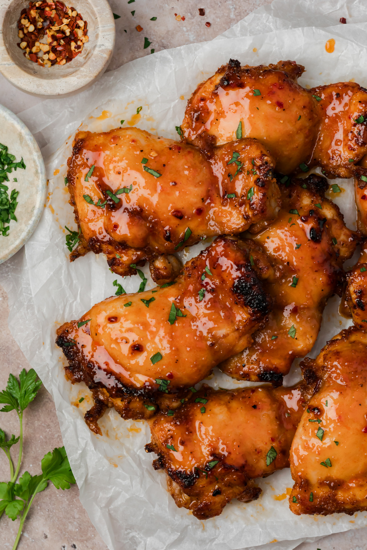 Hot honey chicken thighs glazed with homemade hot honey sauce on parchment paper.