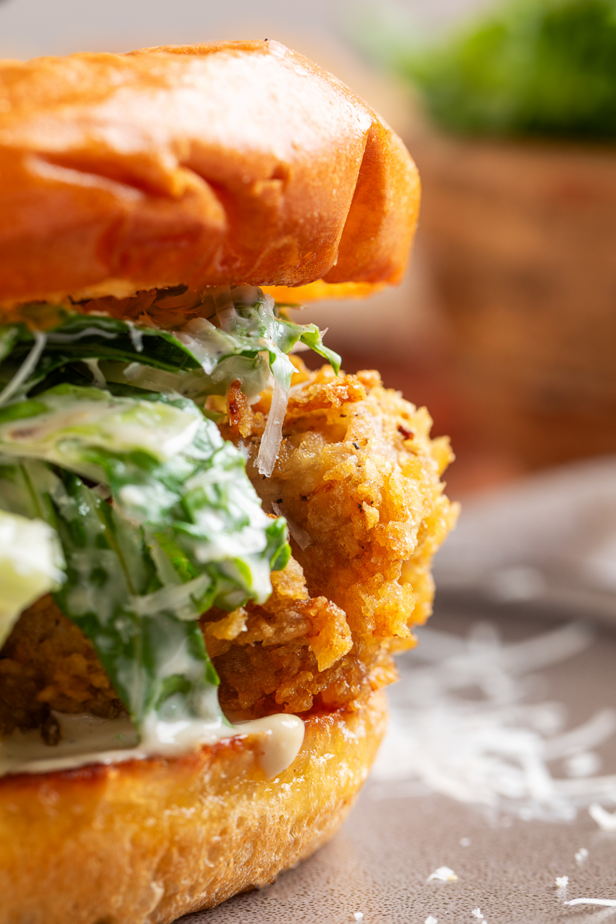 Potato chip-crusted chicken Caesar sandwich Close-up of a potato chip-crusted chicken Caesar sandwich with homemade Caesar salad, Parmesan cheese, and a toasted brioche bun.