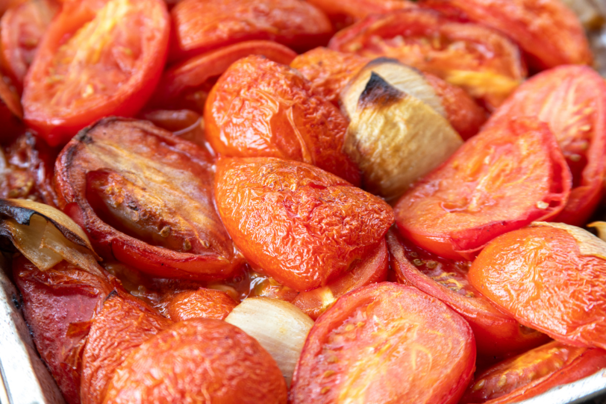 Roma tomatoes, sweet onion and garlic after smoking until softened and lightly charred Smoked Roma tomatoes with charred onion and garlic ready to be blended for Bloody Mary mix