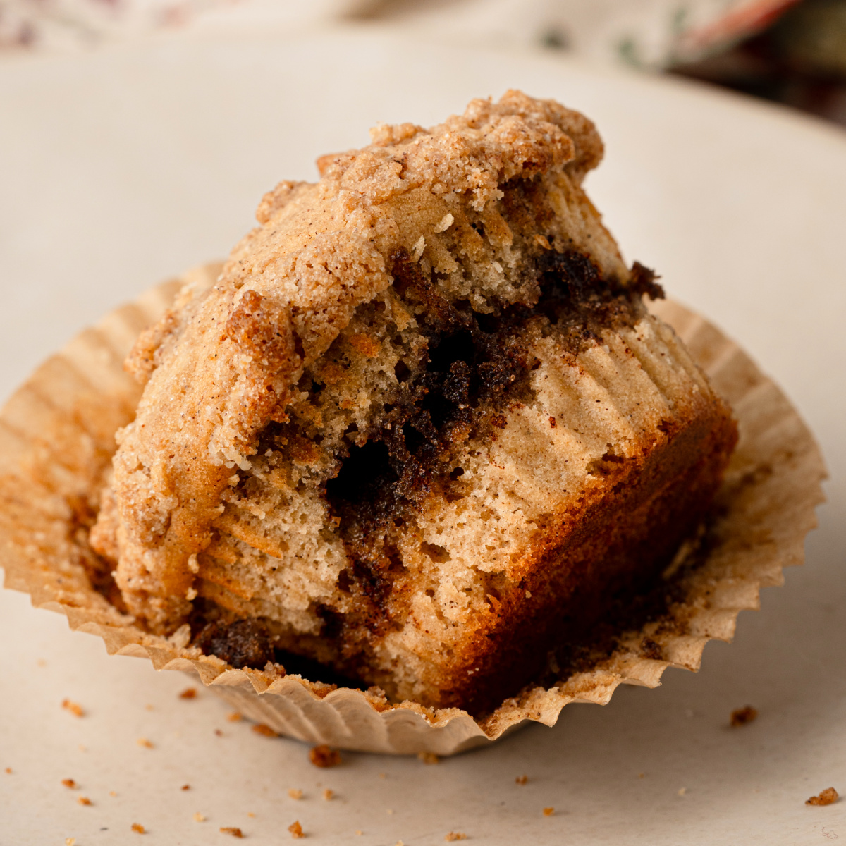 Apple cider streusel muffin broken open to show the cinnamon-spiced interior and streusel topping.