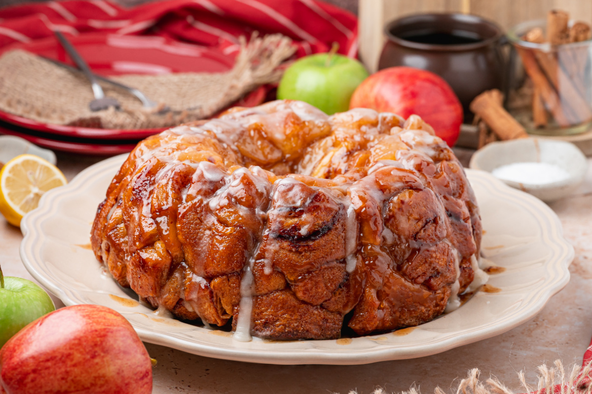 Apple pie cinnamon roll monkey bread baked in a Bundt pan with brown sugar sauce and icing.