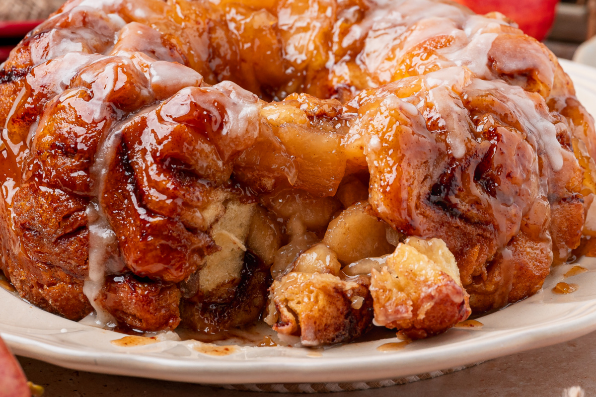 Apple pie cinnamon roll monkey bread pulled apart to show the baked cinnamon roll center and apple pie filling.