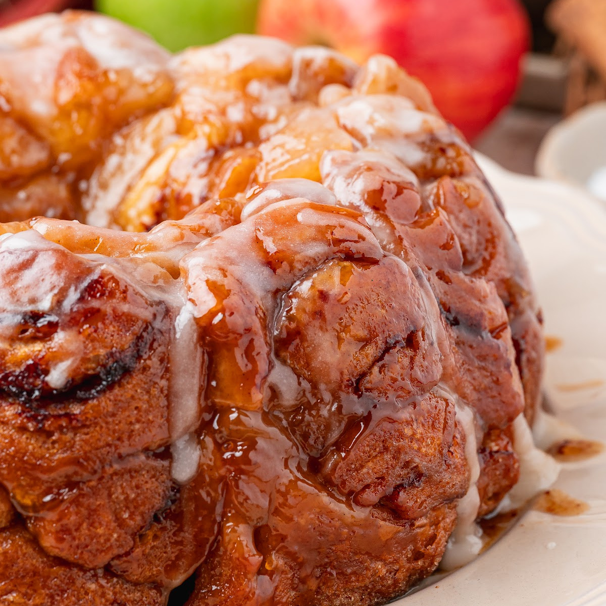 Apple pie cinnamon roll monkey bread with caramelized cinnamon roll pieces, apple filling and warm icing.