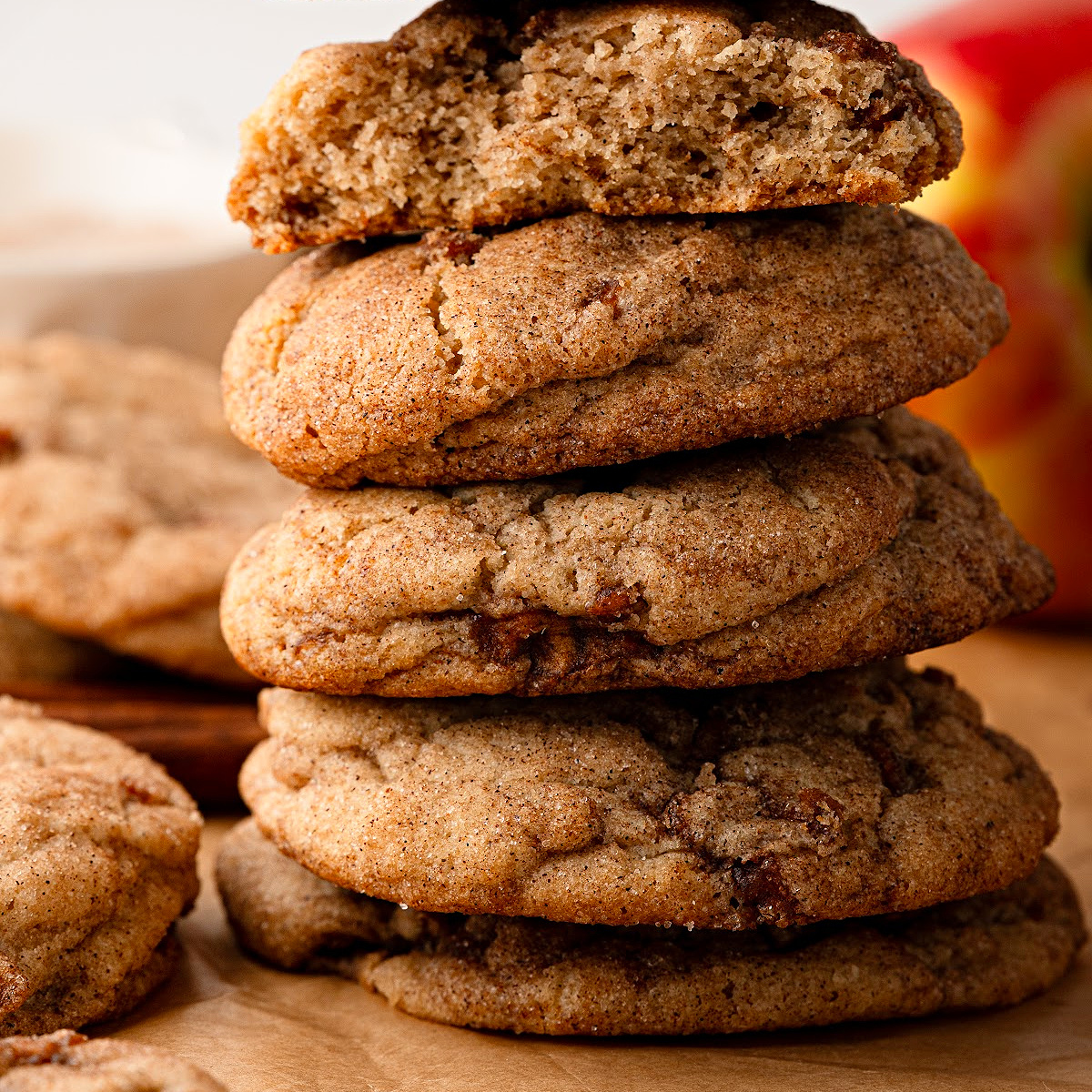 Apple snickerdoodles stacked to show their thick, soft texture and cinnamon-spiced apple pieces