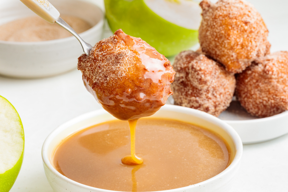 Applesauce fritter dipped in homemade maple caramel sauce Cinnamon sugar applesauce fritter dipped into warm maple caramel sauce