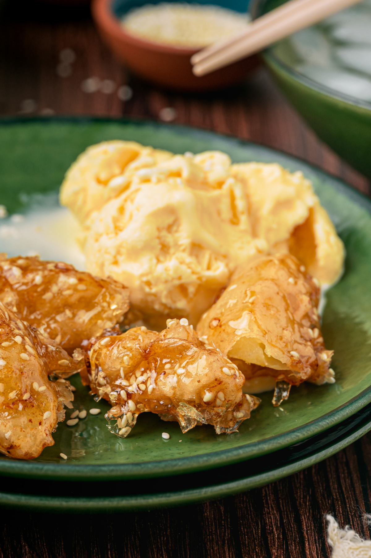Brittle Sesame Caramel Shell on Fried Apples Close-up of fried apple pieces with a thin brittle sesame caramel shell served with vanilla ice cream