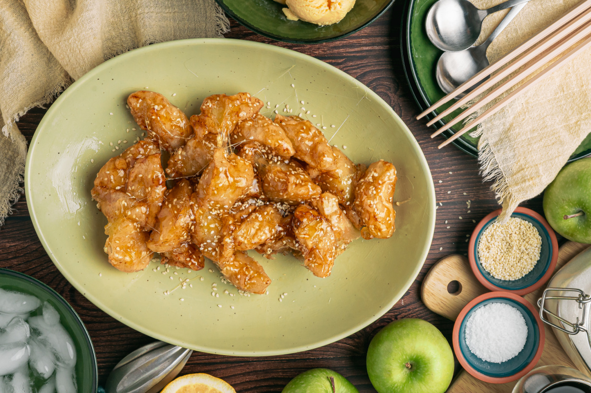 Chinese Toffee Apples Coated in Sesame Caramel Platter of Chinese toffee apples coated in sesame caramel with Granny Smith apples and ice water nearby