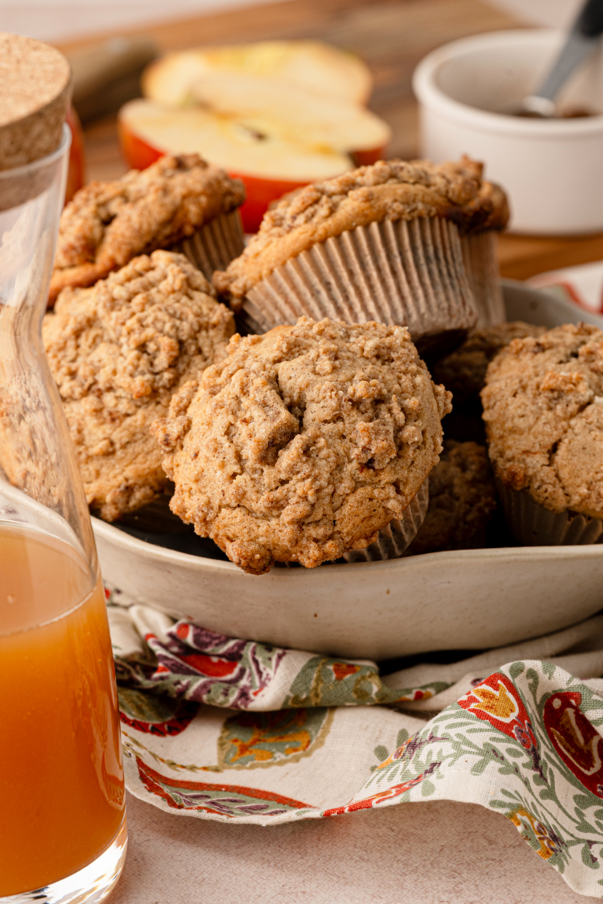 Cider-spiced muffins with cinnamon streusel served alongside fresh apple cider and apples. cider-spiced-streusel-muffins-apple-cider