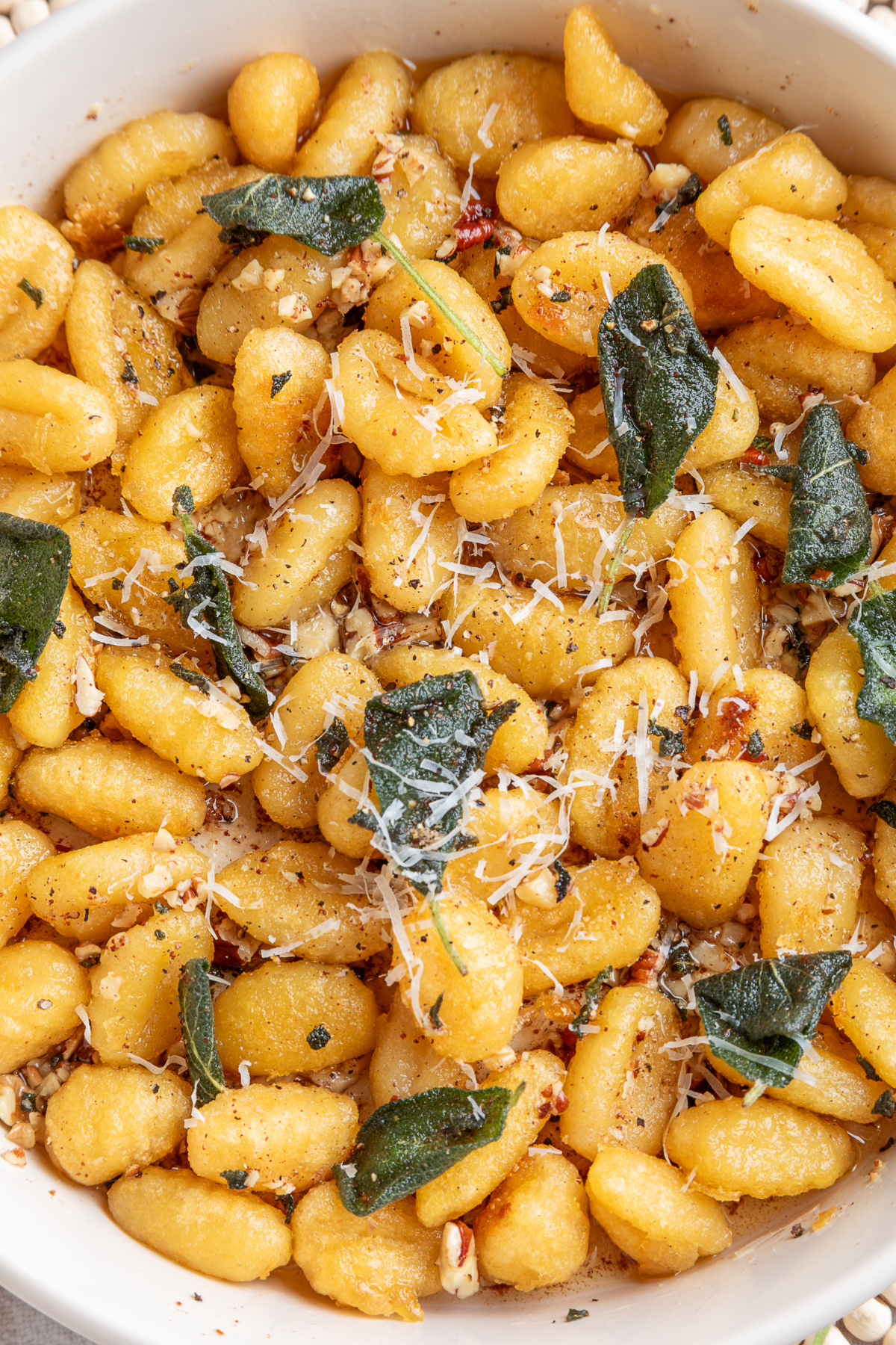 Browned potato gnocchi with fried sage, toasted nuts and grated Parmesan. Crispy gnocchi with sage brown butter topped with fried sage, Parmesan, walnuts and pecans.