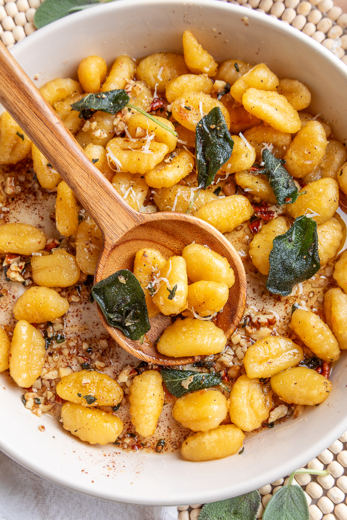 Pan-fried potato gnocchi with sage brown butter and toasted nuts. Crispy gnocchi with sage brown butter, toasted walnuts and pecans, Parmesan and fried sage leaves.