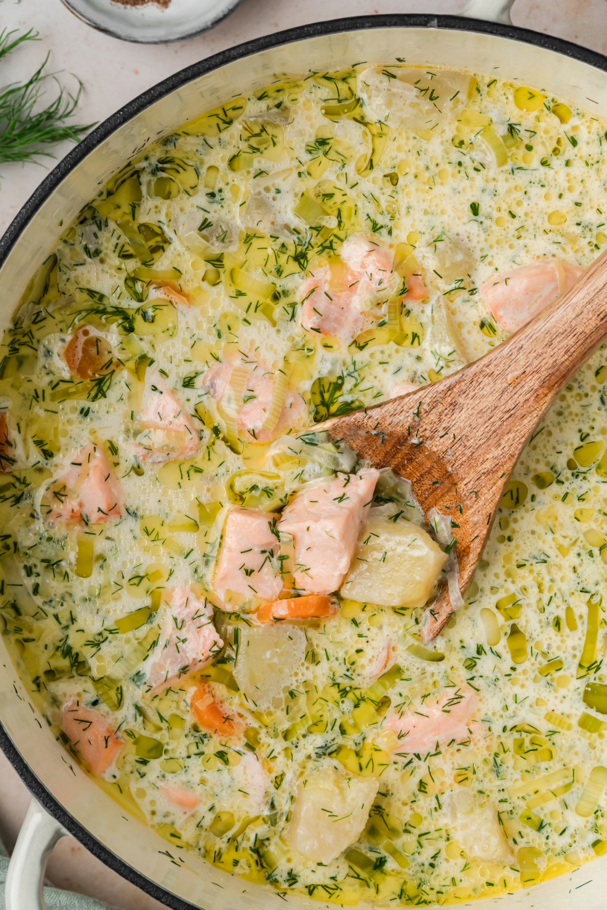 Finnish salmon soup with tender salmon, potatoes, leeks, carrots, cream and fresh dill in a Dutch oven.