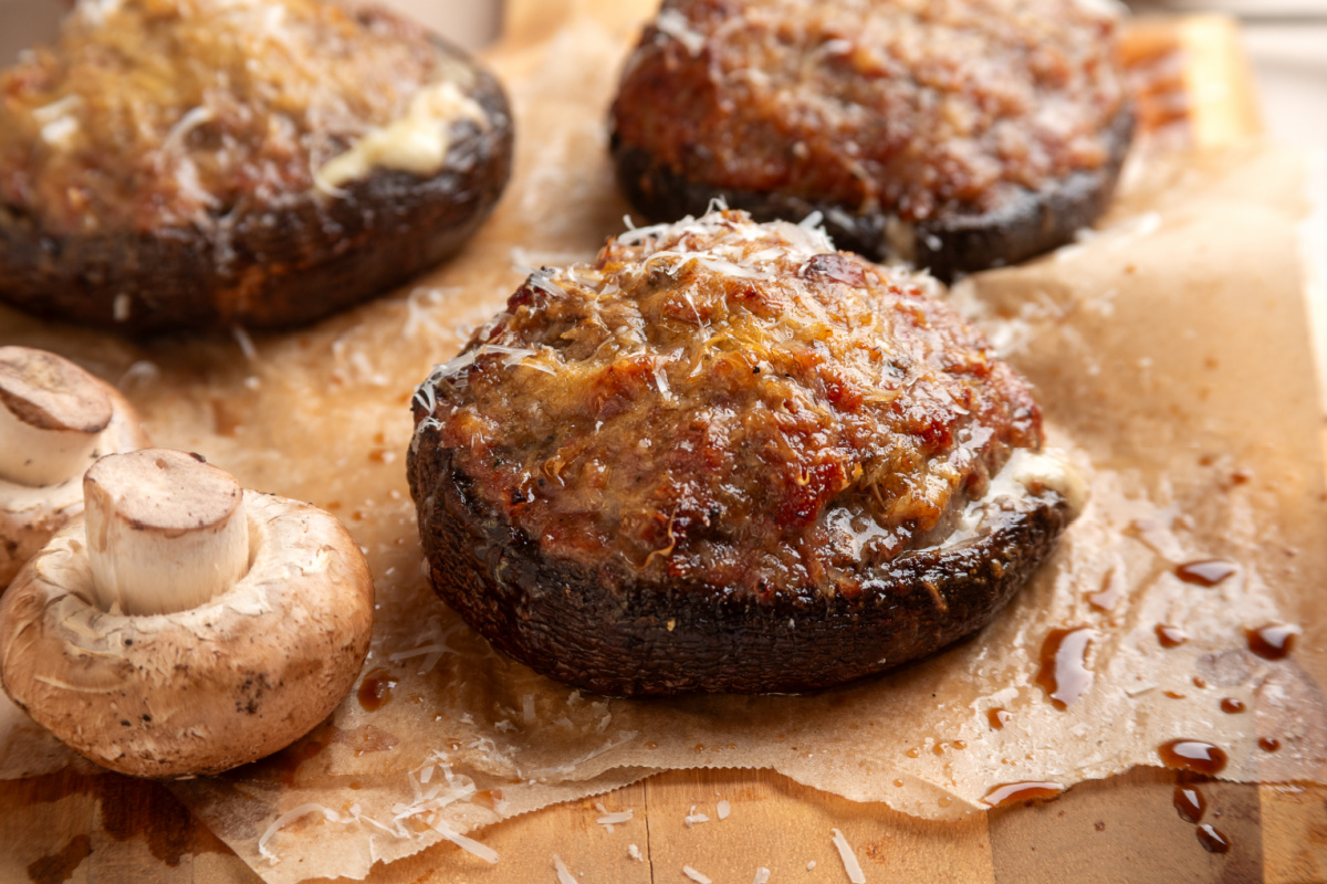 Large portobello mushrooms filled with sweet Italian sausage and cheese after grilling. Grilled portobello mushrooms stuffed with Italian sausage, mozzarella and Parmesan
