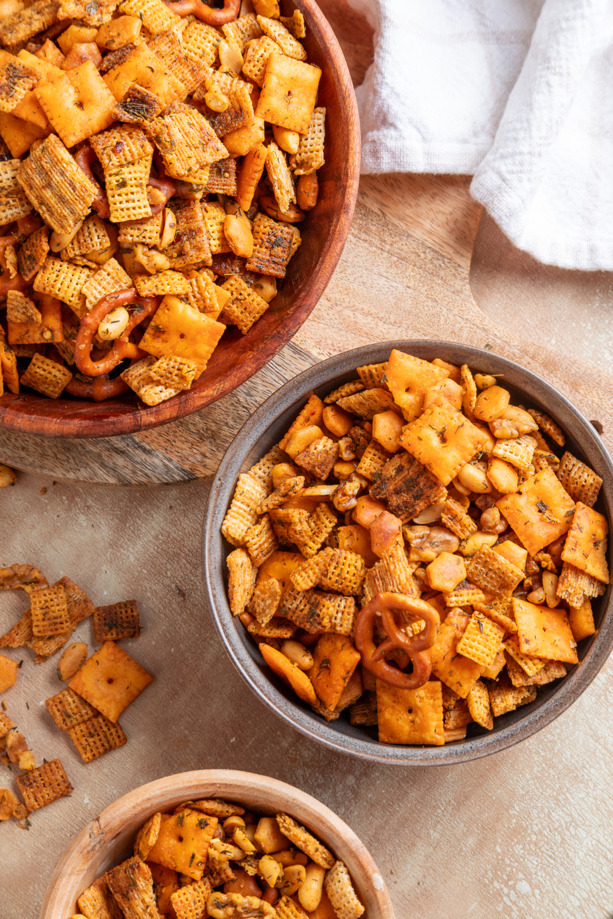 Bowls of Chex cereal, Cheez-It crackers, pretzels and nuts baked with cowboy butter seasoning