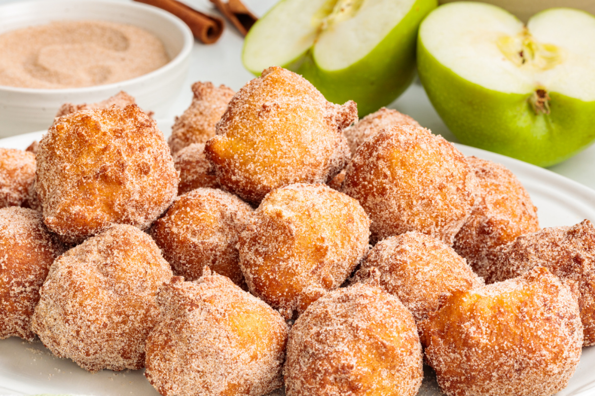 Warm applesauce fritters with cinnamon sugar and Granny Smith apples Homemade applesauce fritters coated in cinnamon sugar beside sliced Granny Smith apples