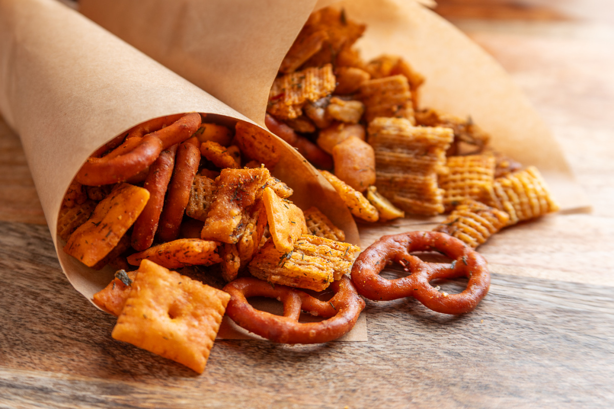 Baked Chex mix with Cheez-It crackers, Triscuits, pretzels and nuts served in brown paper cones