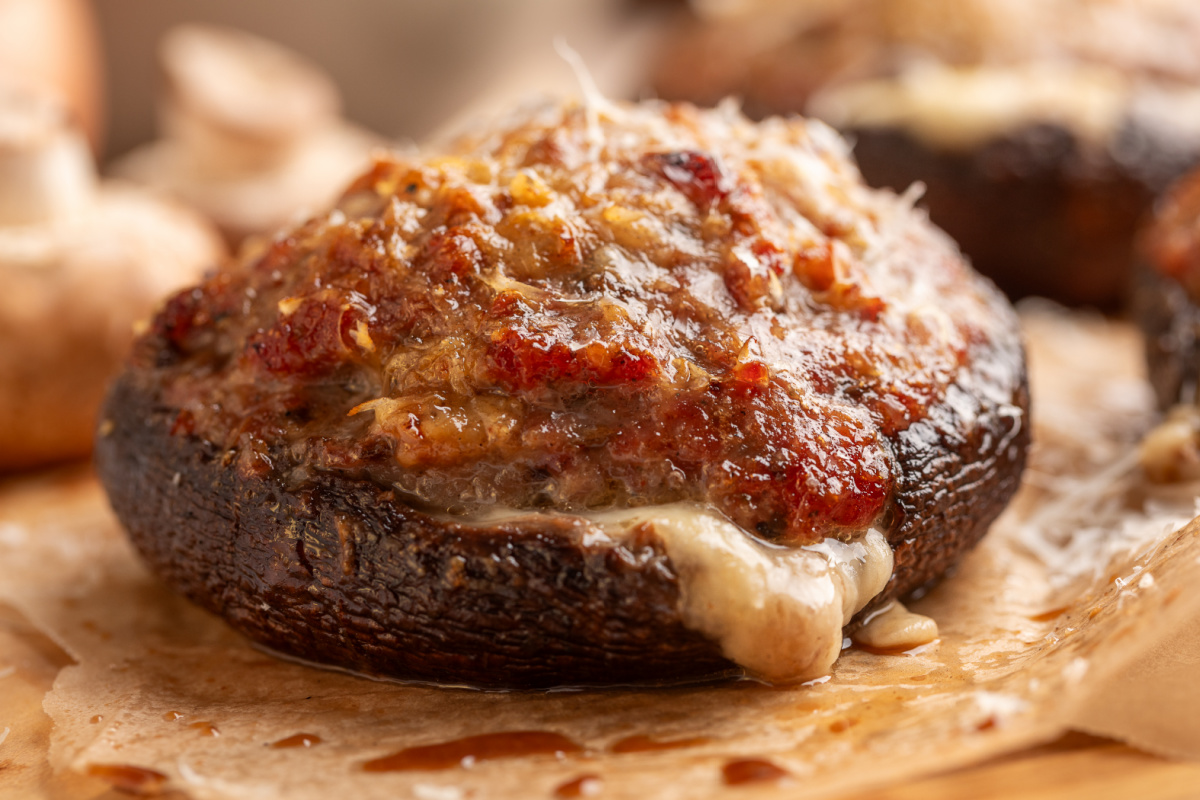 Grilled portobello filled with sweet Italian sausage and Parmesan, with melted mozzarella spilling from underneath. Italian sausage stuffed portobello mushroom with mozzarella melted underneath