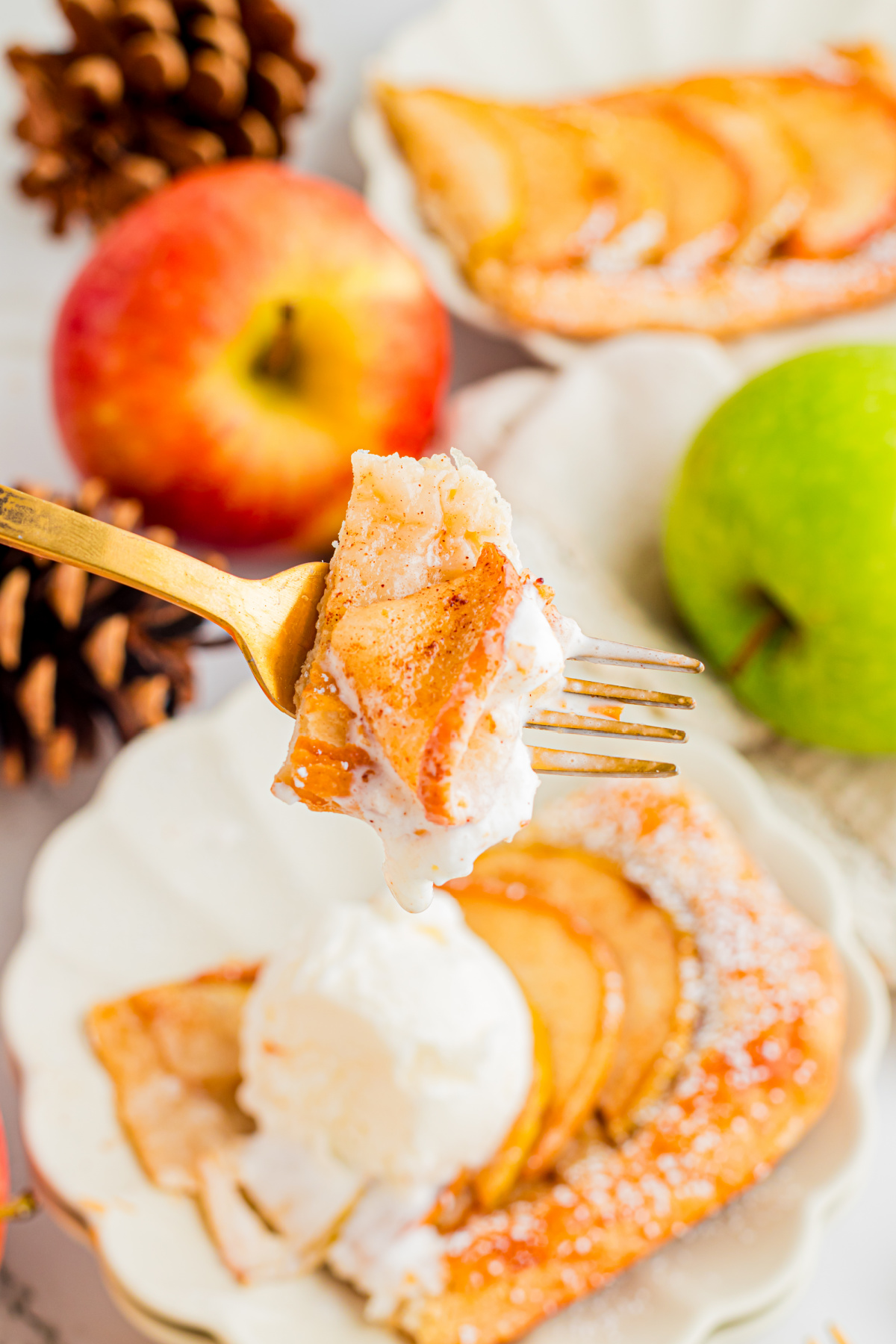 Warm puff pastry apple tart served with vanilla ice cream Bite of puff pastry apple tart with cinnamon apple and vanilla ice cream
