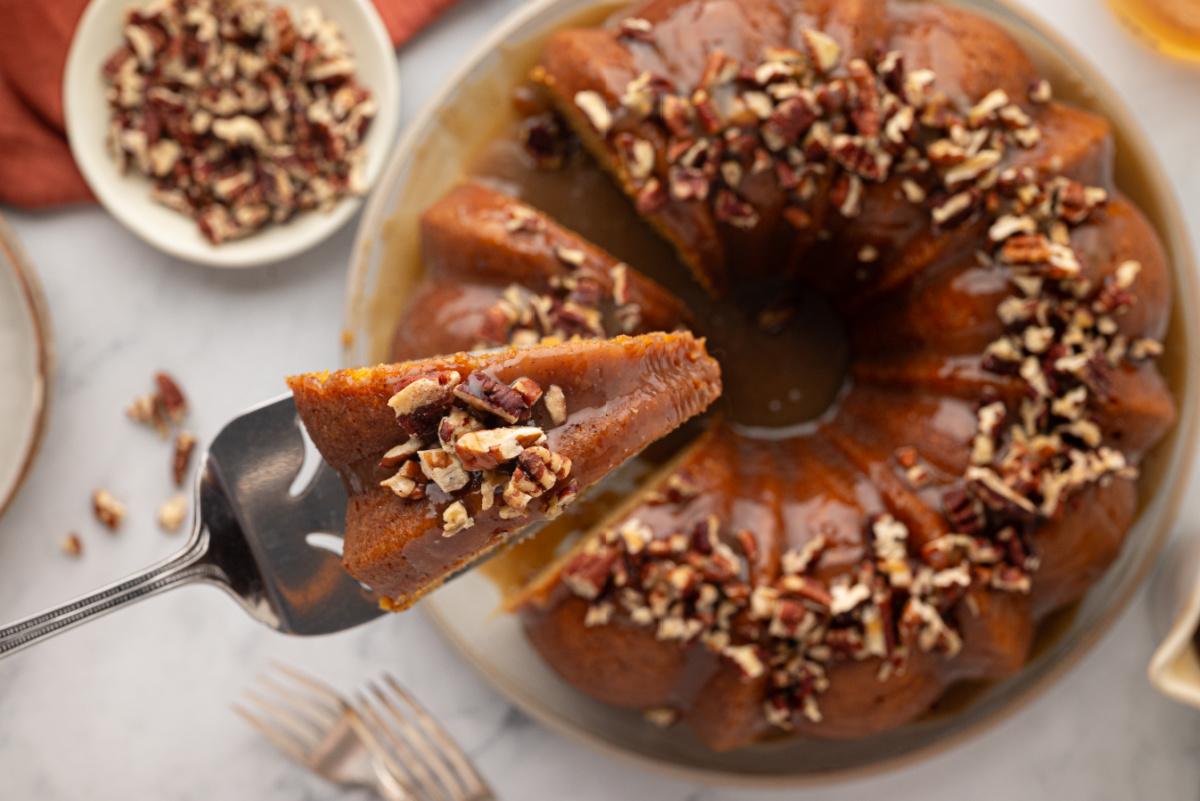 A slice of brown butter sweet potato Bundt cake topped with dark rum caramel and toasted pecans. sweet-potato-bundt-cake-slice-rum-caramel