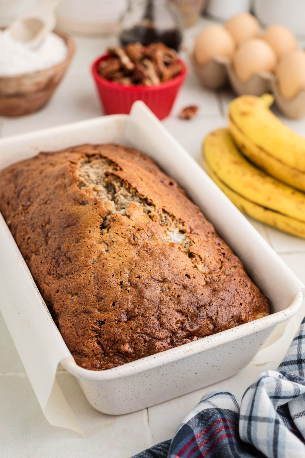 Banana bread with cottage cheese baked in a white loaf pan with a browned, cracked top.