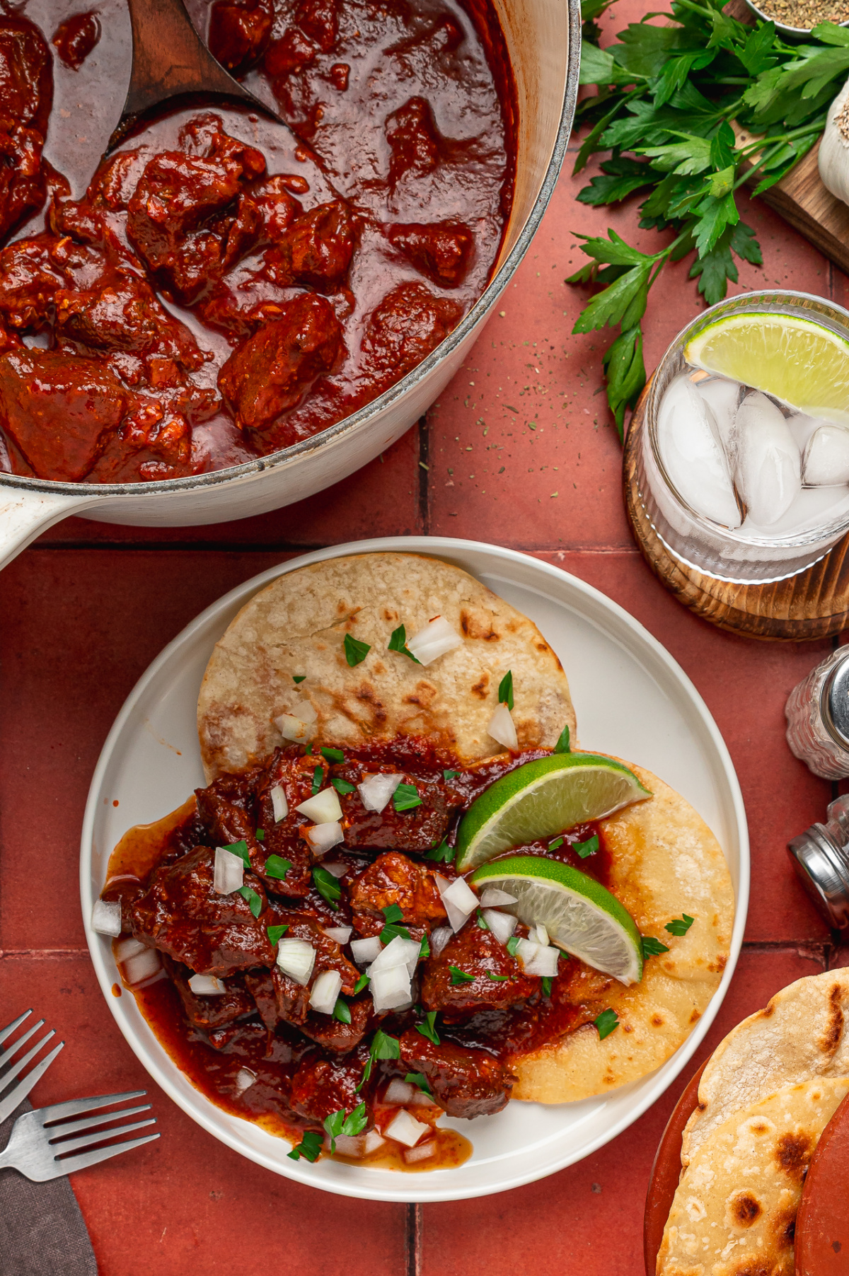 Carne adovada served over warm tortillas with chopped onion, parsley and lime