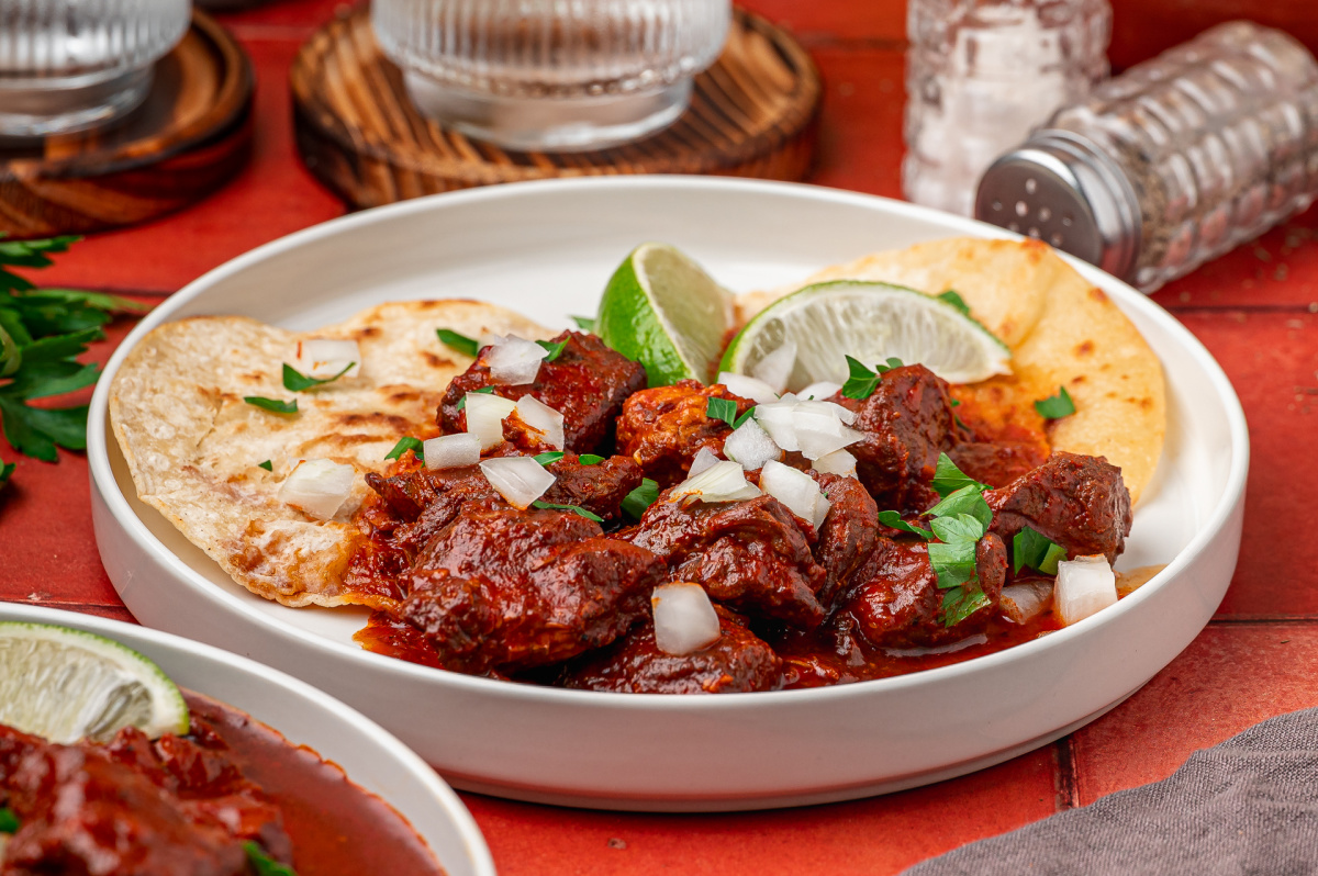 Carne adovada served with warm tortillas, lime, chopped onion and parsley