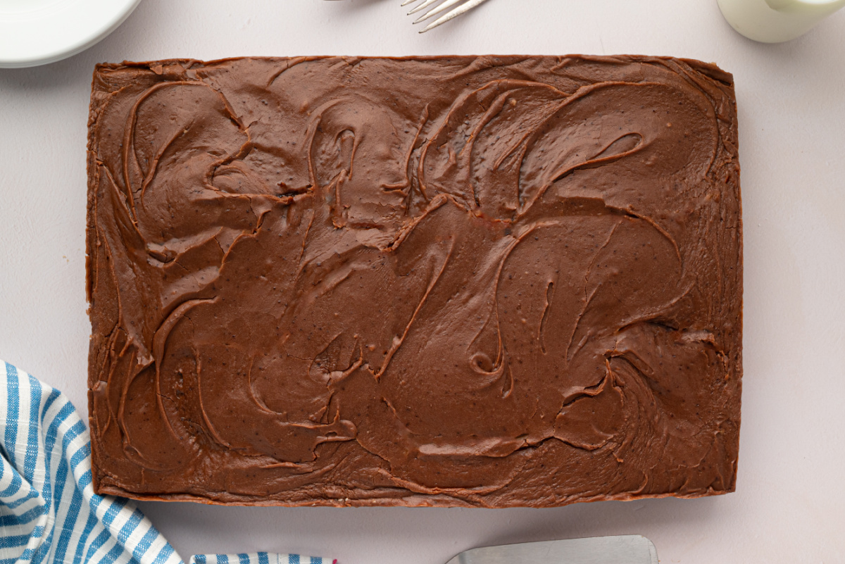 Thick Chocolate Sheet Cake with Brown Butter Fudge Frosting Overhead view of a rectangular chocolate sheet cake covered with thick, swirled brown butter chocolate frosting.
