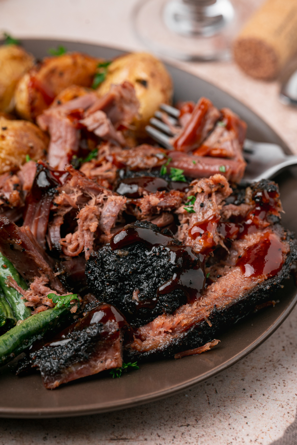 Coffee Rubbed Oven Brisket with sliced beef, pulled brisket, dark coffee crust, and barbecue sauce on a dinner plate.