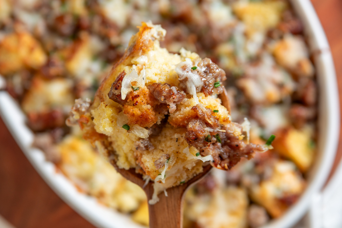 Spoonful of cornbread breakfast casserole with sausage, melted cheese and chives