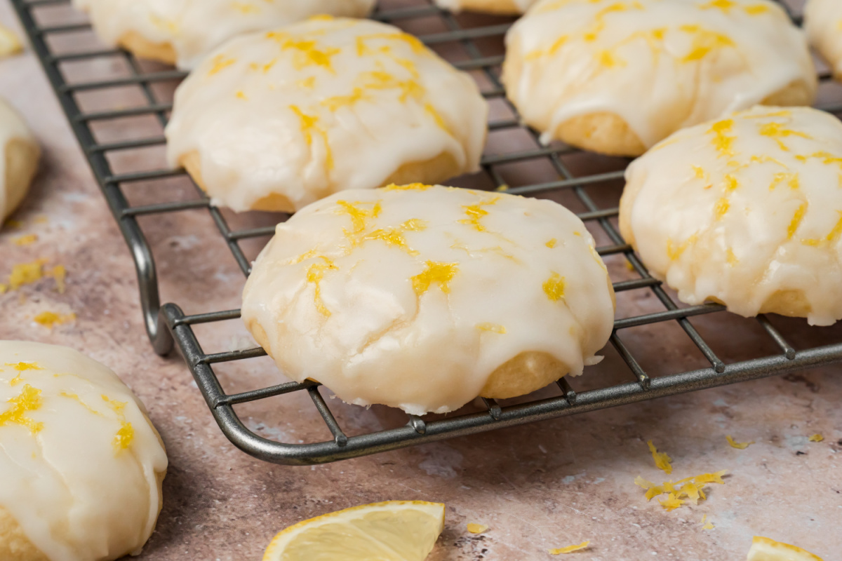 Lemon Ricotta Cookies Cooling After Glazing Glazed lemon ricotta cookies topped with fresh lemon zest on a cooling rack