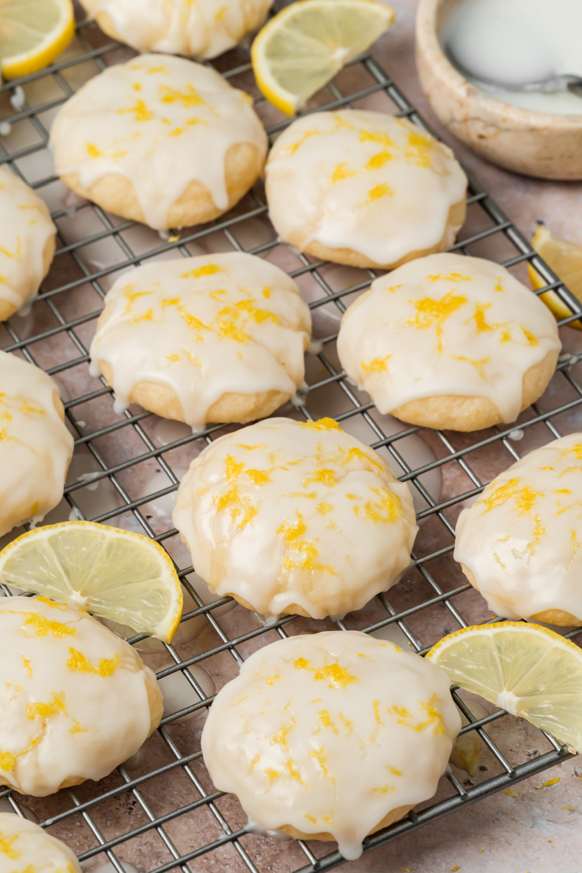 Glazed Ricotta Cookies with Fresh Lemon Zest Soft ricotta cookies covered with lemon glaze and fresh lemon zest on a cooling rack