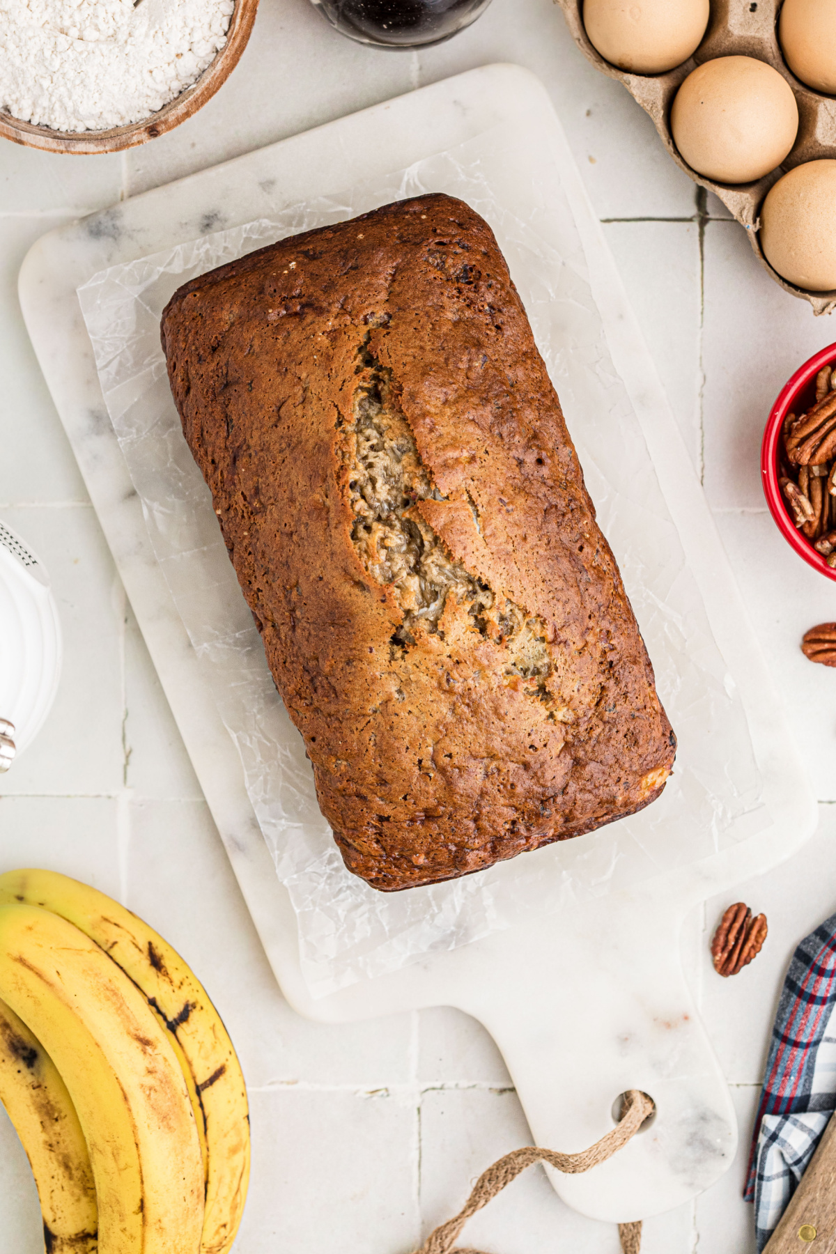 Overhead view of banana bread with cottage cheese showing a deeply browned top and a crack down the center.