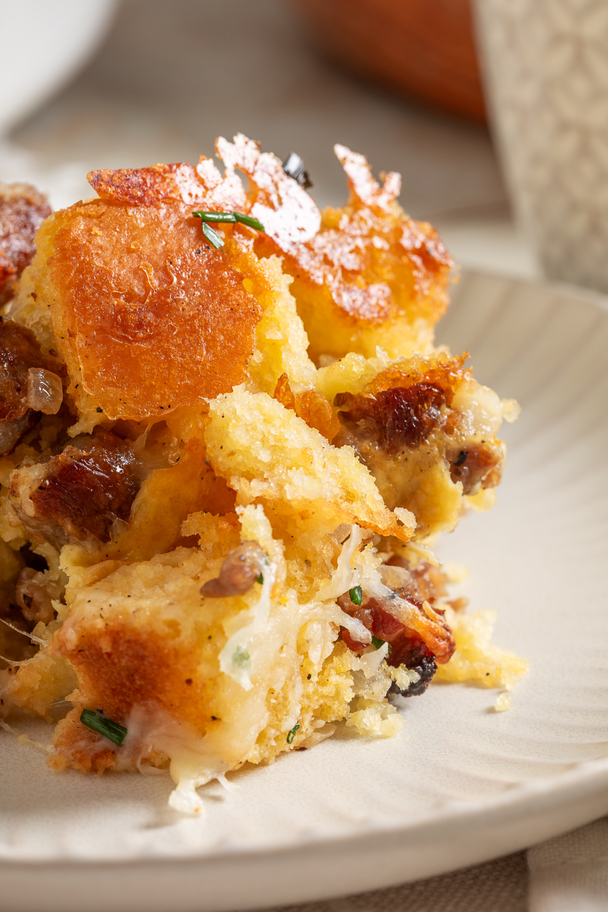 Plated leftover cornbread breakfast casserole with browned cornbread, sausage and melted cheese