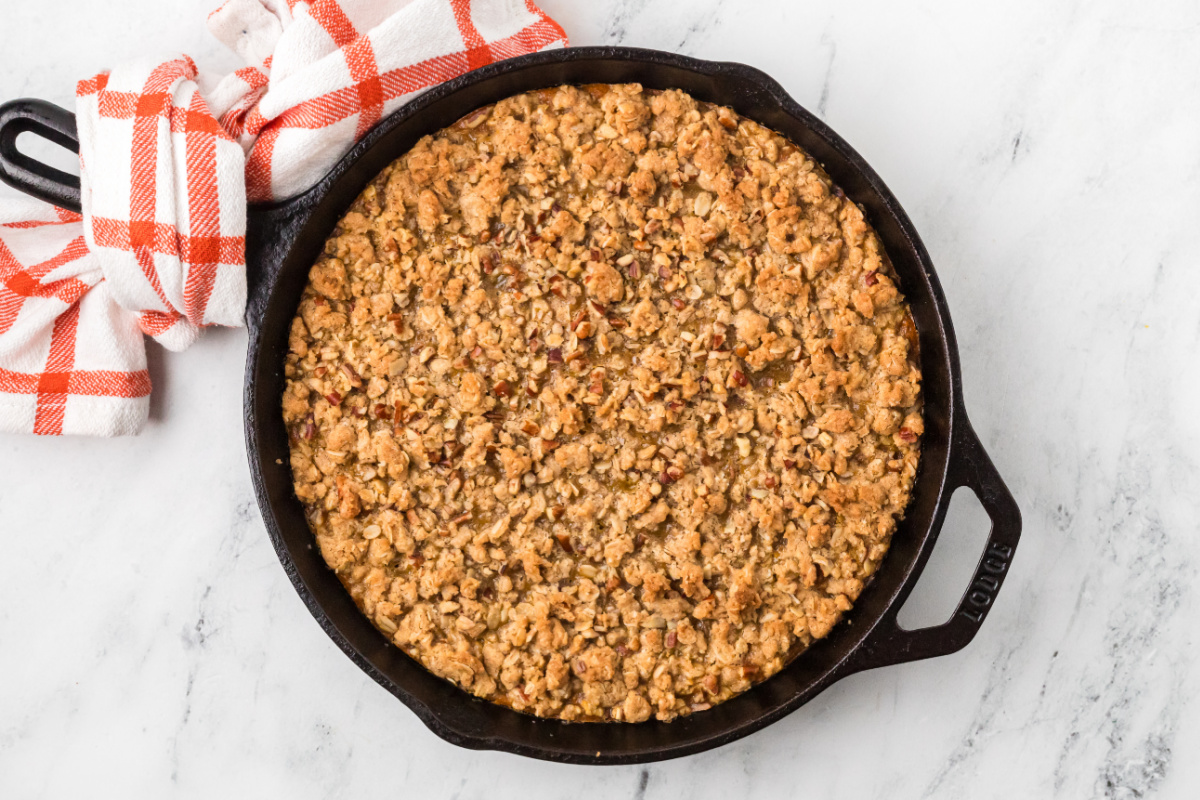 Freshly baked pumpkin custard covered with buttery oats and chopped pecans in a cast-iron skillet. Pumpkin crisp baked in a cast-iron skillet with a golden oat and pecan topping.