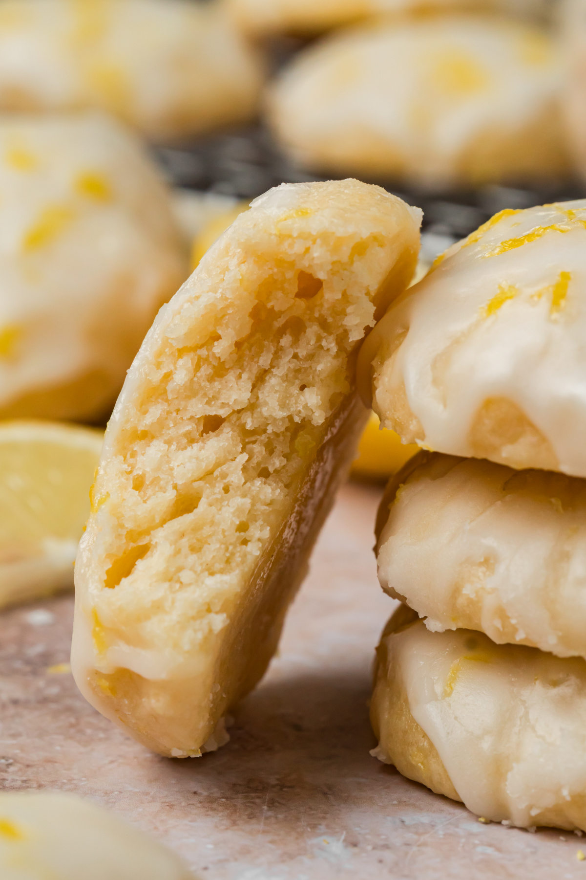 Cut ricotta cookie showing the soft cake-like center beneath fresh lemon glaze