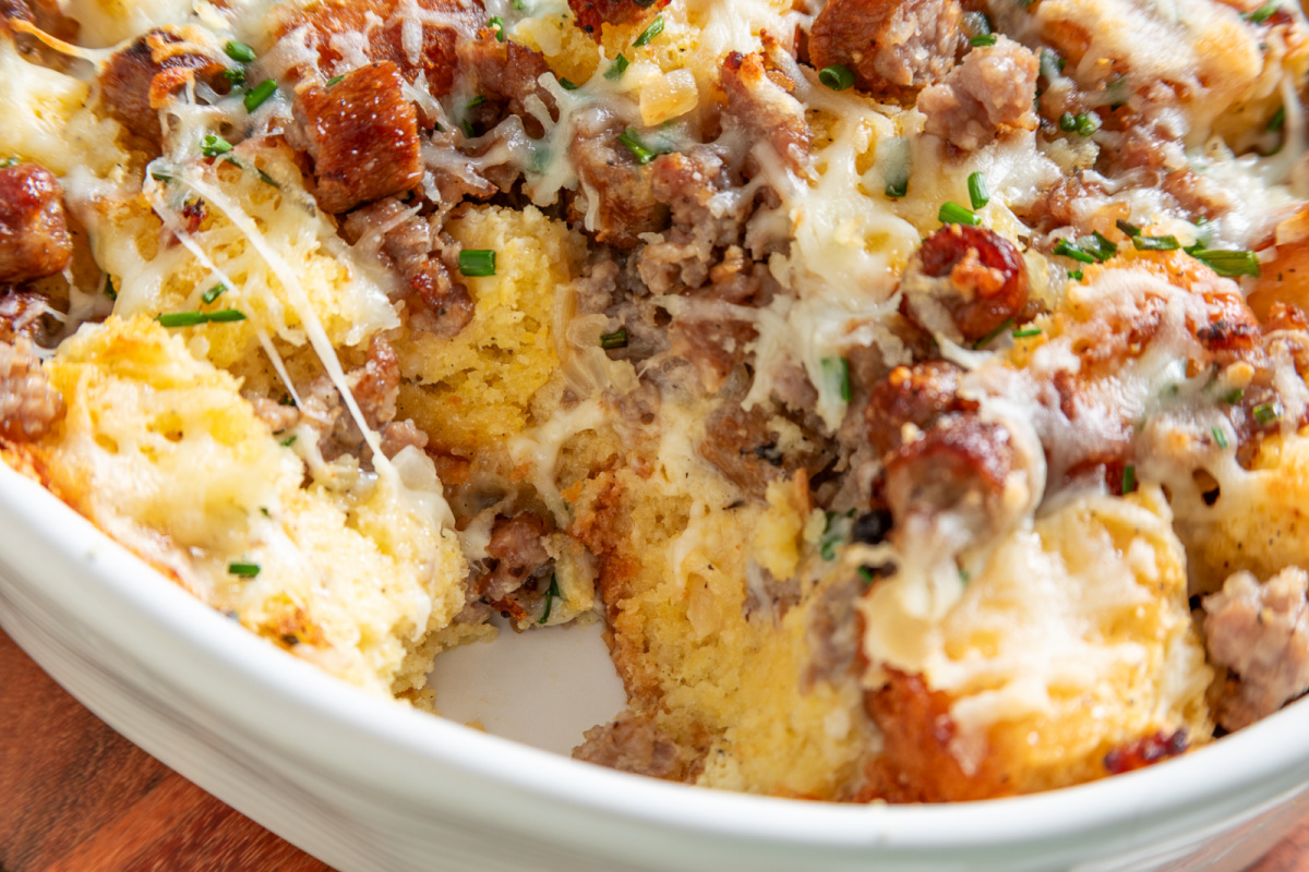 Inside of cornbread breakfast casserole showing large cornbread pieces, two kinds of sausage and melted cheese