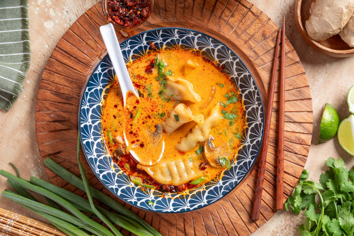 Thai Dumpling Soup with Coconut Curry and Chili Crisp Overhead view of Thai Dumpling Soup with pork potstickers, coconut curry broth, mushrooms, cilantro, and chili crisp.